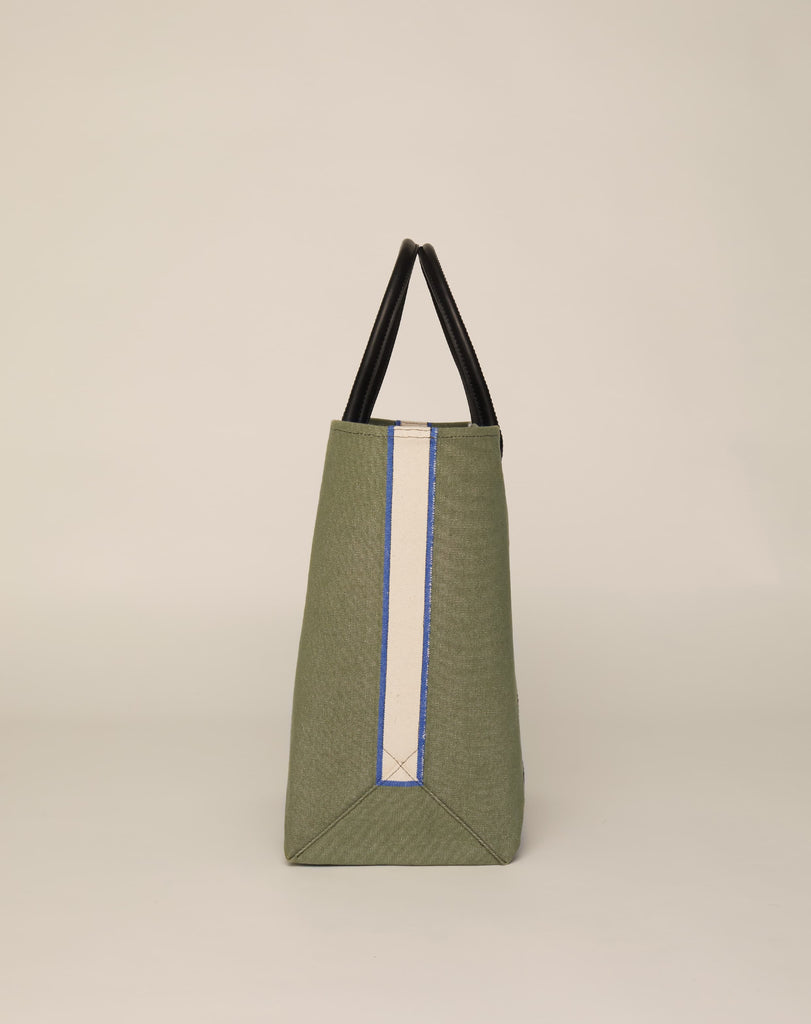 Side image of medium-sized classic canvas tote bag in sage colour with black leather handles and contrasting stripes.