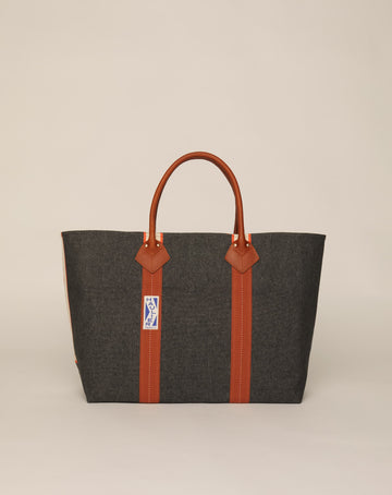 Image of classic canvas tote bag in washed black colour with tan leather handles and contrasting stripes.